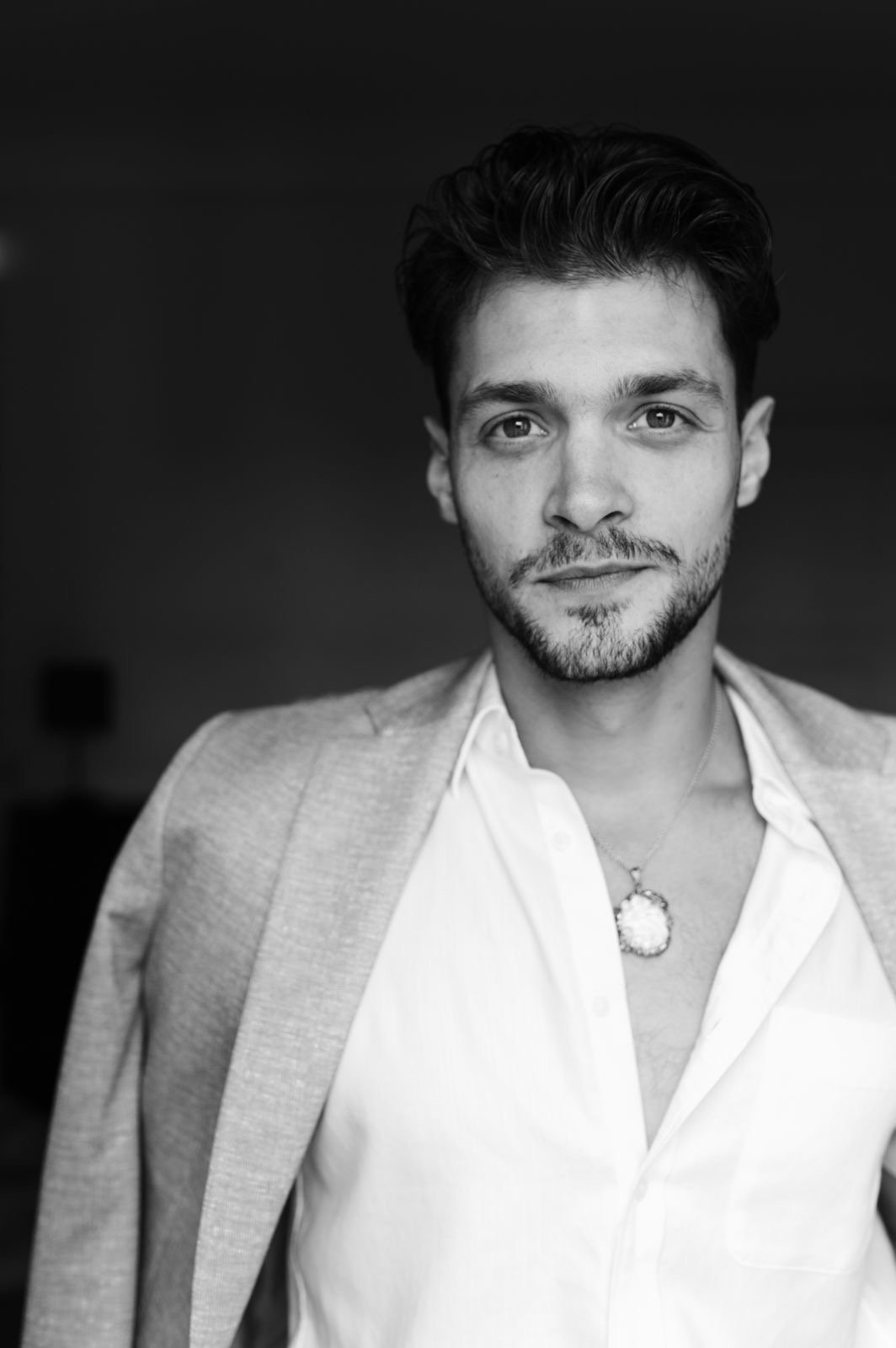 Callboy im Anzug schaut verspielt in die Kamera