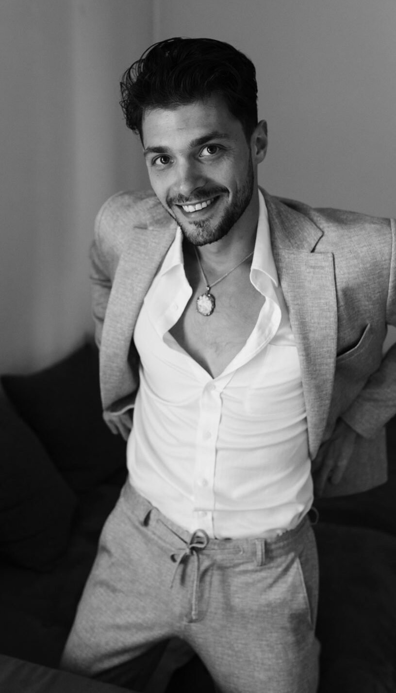 Callboy schaut lächelnd in die Kamera